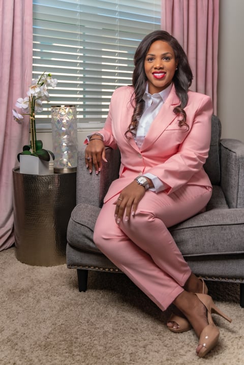 Ebony Russ seated in pink suit